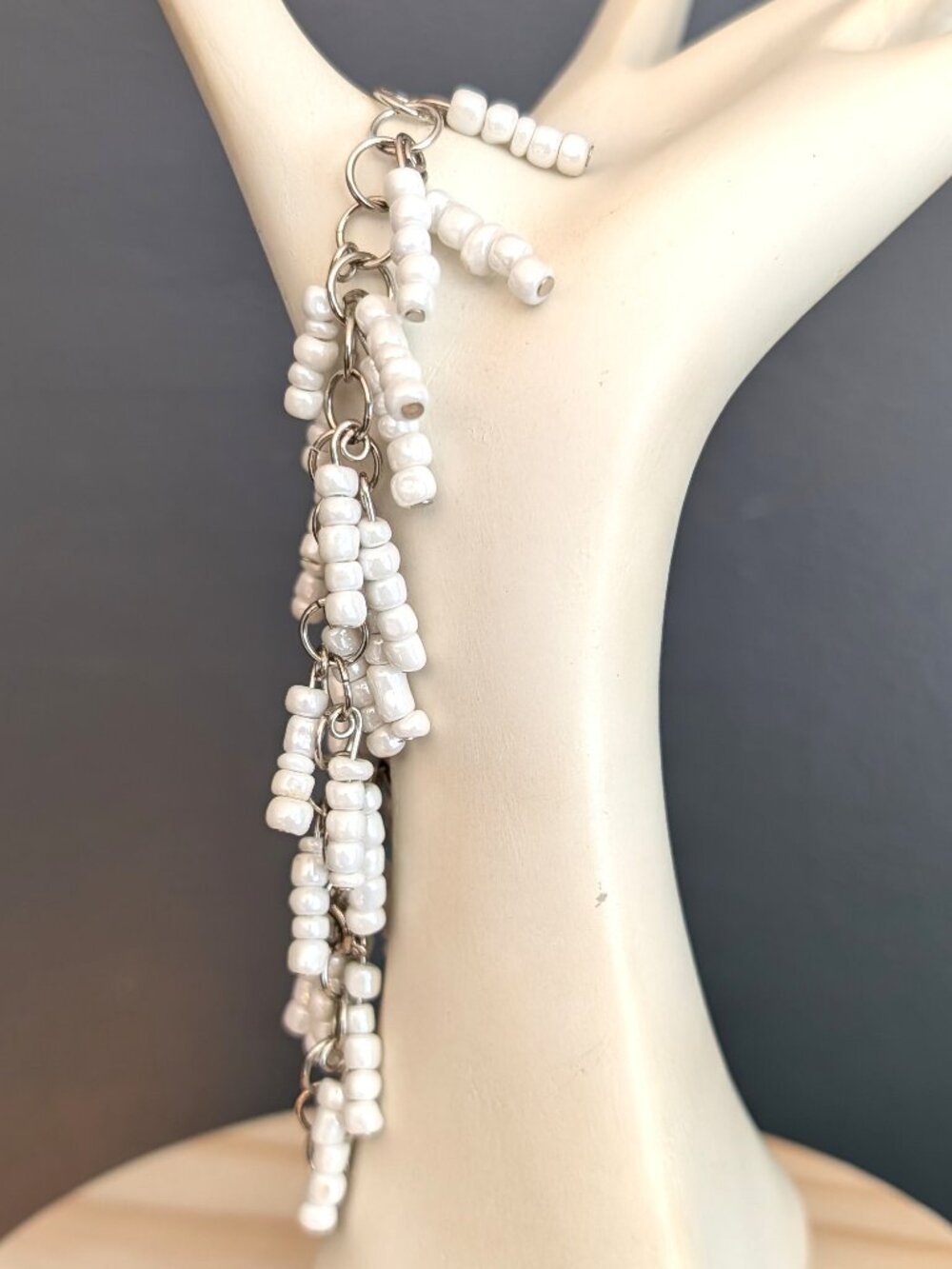White beaded hanging fringe silver tone bracelet